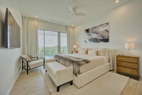One Canal Point: Stylish bedroom with bed, seating area, and serene balcony view