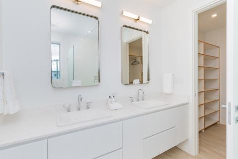 Modern bathroom with dual sinks, mirrors, and glass shower enclosure