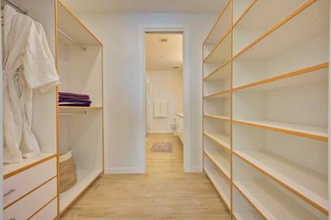 One Canal Point: Walk-in closet with shelves and view into a modern bathroom