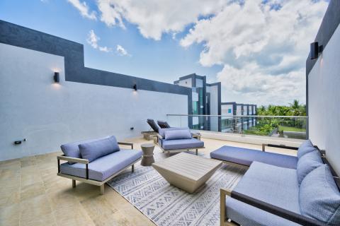 Modern rooftop terrace with stylish furniture and tropical view