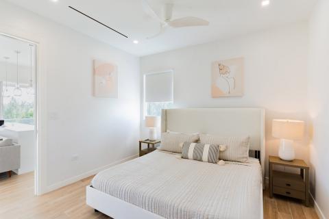 Modern bedroom with beige headboard and abstract art