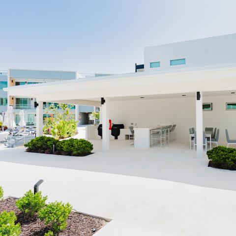 This image shows an outdoor area of a modern, stylish building, most likely part of a residential complex or a resort