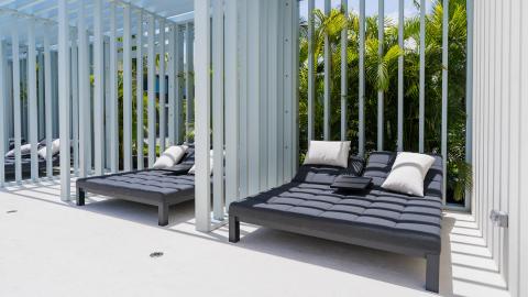 Modern outdoor relaxation area with sun loungers and tropical plants