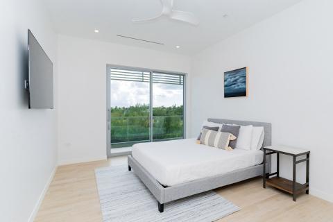 Modern bedroom with grey headboard and sliding glass door