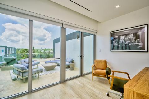 Modern Interior Room with Sliding Glass Doors to Patio Overlooking Tranquil Landscape