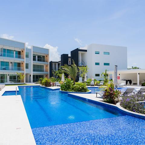 This image displays a modern residential complex featuring a luxurious swimming pool