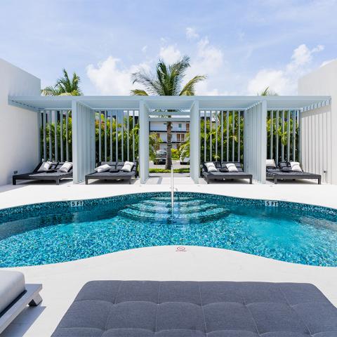 This image features a luxurious pool area at an upscale resort or private residence