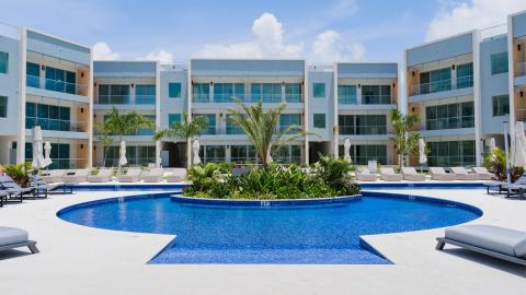 Modern resort-style pool area with sun loungers and palm trees