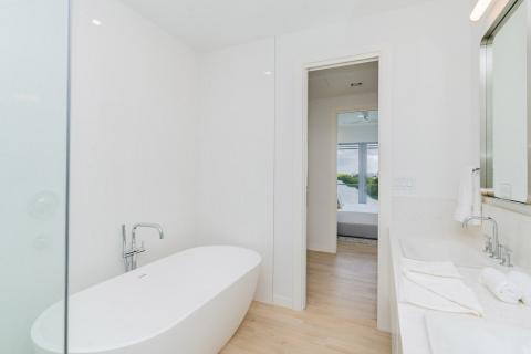 Modern bathroom with freestanding bathtub and white hexagonal tiling