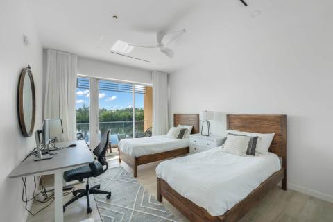 ONE Canal Point: Modern Bedroom with Twin Beds and Scenic Patio View