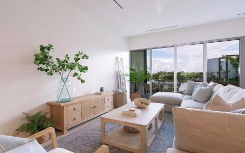 This image features a contemporary and well-lit living room space, designed with a neutral color palette and natural materials