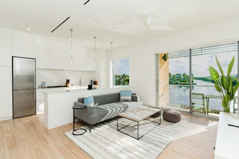 The image shows a modern and bright interior space that includes both a kitchen and a living area