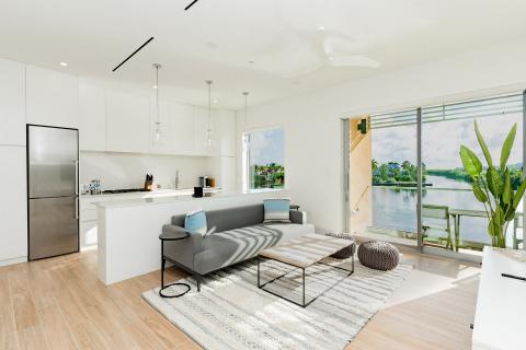 The image shows a modern, open-concept living space with a kitchen and lounge area