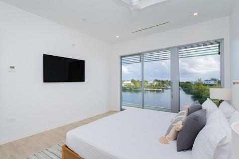 Minimalist modern bedroom with large bed and lake view