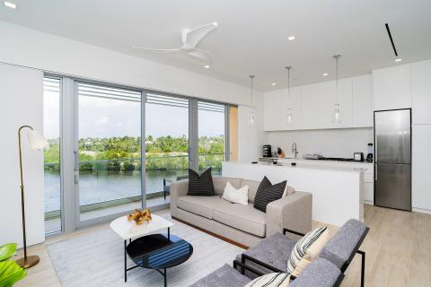 This image shows a modern and sleek living room combined with a kitchen area