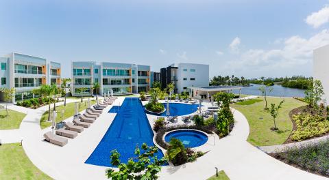 The image features a modern residential complex with a luxurious outdoor setting