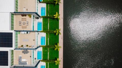 One Canal Point: Aerial view of modern residential houses with pools and solar panels by the water