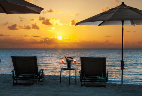 Beach sunset with lounge chairs  