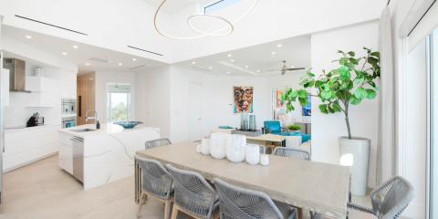 This image shows a bright and modern open-plan living space that combines a kitchen, dining area, and a lounge