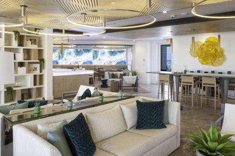 This image shows a modern and stylish interior space that appears to be a lounge or common area in a corporate or residential building