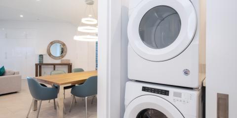 The image shows a modern interior space, predominantly featuring a dining area and a laundry setup