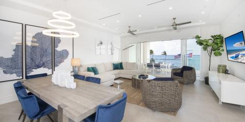 This image shows a modern and bright coastal living space featuring an open-plan design with both a living and dining area