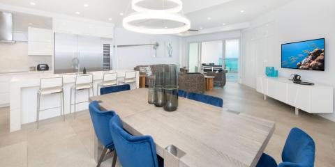 This image displays a modern and stylish interior of a home, featuring a combined kitchen, dining, and living area