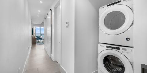 This image shows a modern home interior, specifically a hallway with a laundry setup on the right side