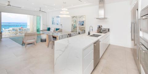 This image shows the interior of a modern, beachfront house featuring a blend of living and kitchen areas