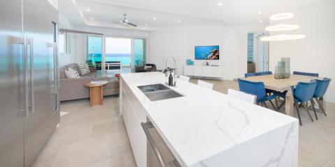 This image shows a modern, luxurious interior of a beachfront home