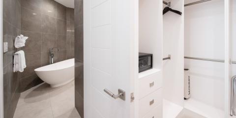 The image captures a modern bathroom and an adjacent closet