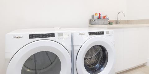 The image shows a laundry room featuring two Whirlpool appliances, specifically a washing machine and a dryer