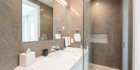 The image shows a modern bathroom interior featuring a large mirror covering most of the wall, a vanity with a white countertop, and a rectangular undermount sink