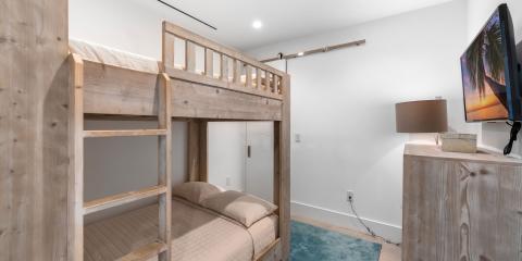 The image shows a modern bedroom featuring a wooden bunk bed with two levels