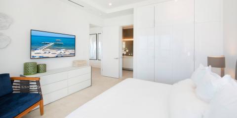 The image shows a modern, minimalist bedroom with bright, neutral colors