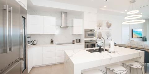 The image shows a modern, upscale kitchen with predominantly white and marble finishes