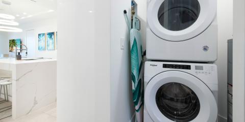 This image features a modern, well-appointed laundry area adjacent to a kitchen space