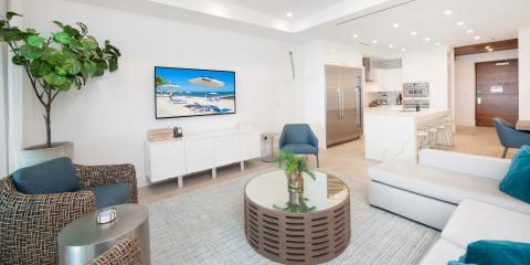 This image showcases a modern, bright living room that seamlessly transitions into a kitchen area