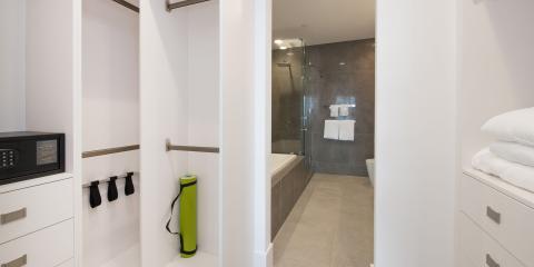 This image shows a modern, minimalist bathroom area connected to a bedroom