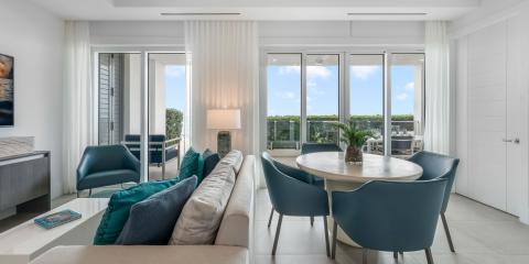 This image features a modern and elegantly designed living room that opens up to a dining area
