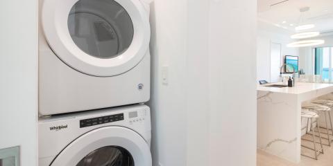 This image features a modern interior with a stack of Whirlpool laundry appliances (a washer below and dryer above) on the left side