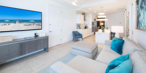 This image showcases a modern, bright living room with a view of the kitchen and dining area