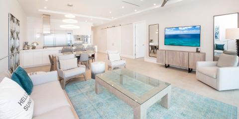 This image shows a modern, well-lit living space that integrates a living room and kitchen in an open floor plan