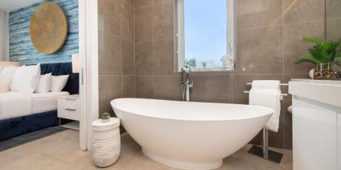 This image shows a stylish, modern bathroom that is partially visible through an open doorway, which leads from an adjacent bedroom