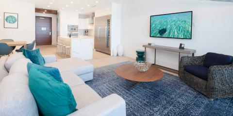 This image shows a well-decorated modern living room that transitions into an open kitchen area