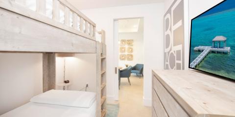 The image shows a stylish interior space featuring a bunk bed setup made of natural wood
