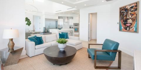 This image shows a modern, well-lit living space that spans into an open kitchen