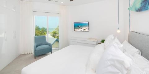 The image depicts a bright and modern bedroom with a coastal theme
