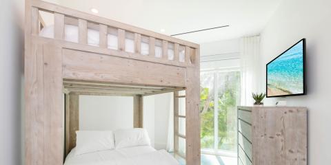 The image depicts a modern, well-lit bedroom featuring a large wooden loft bed