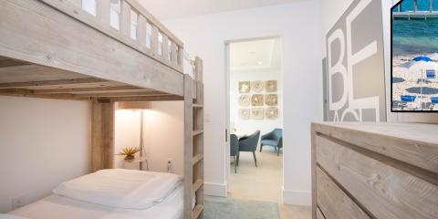 This image shows a modern bedroom featuring a wooden bunk bed with a lower and upper mattress